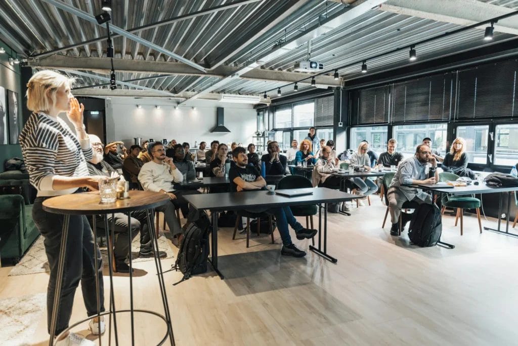 Eine Gruppe von Menschen sitzt in einem Konferenzraum während einer Präsentation.